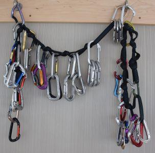 a couple dozen carabiners hang from webbing attached to two bolts